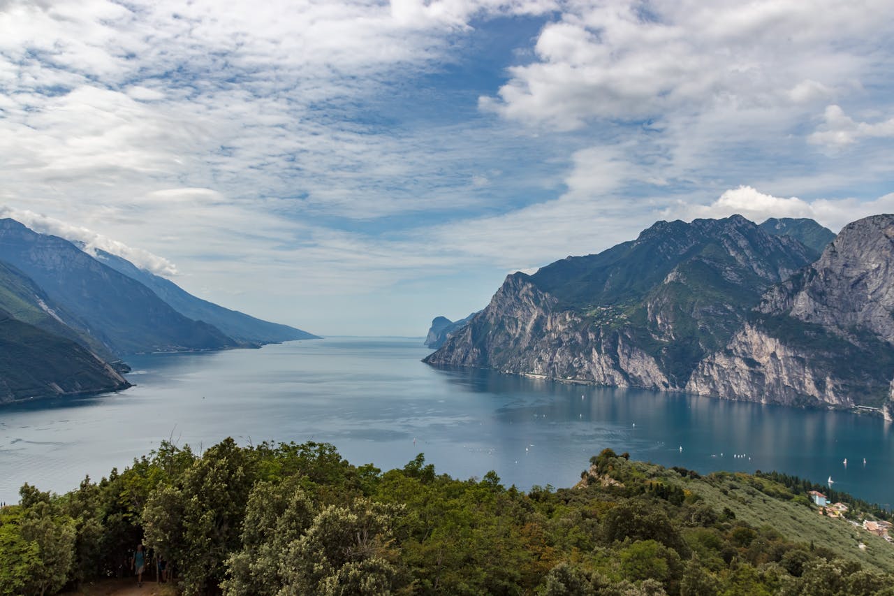 Breathtaking view of a lake with majestic mountains under a cloudy sky.