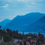 A beautiful panoramic view of Malcesine with Lake Garda and surrounding mountains at twilight.
