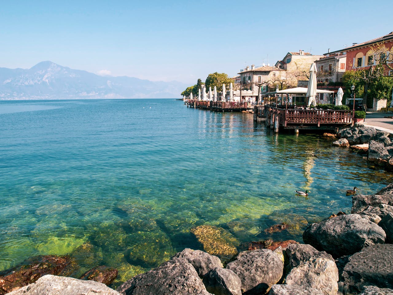 Idyllic view of Gardone Riviera with clear turquoise water and charming architecture. Perfect for travel inspiration.