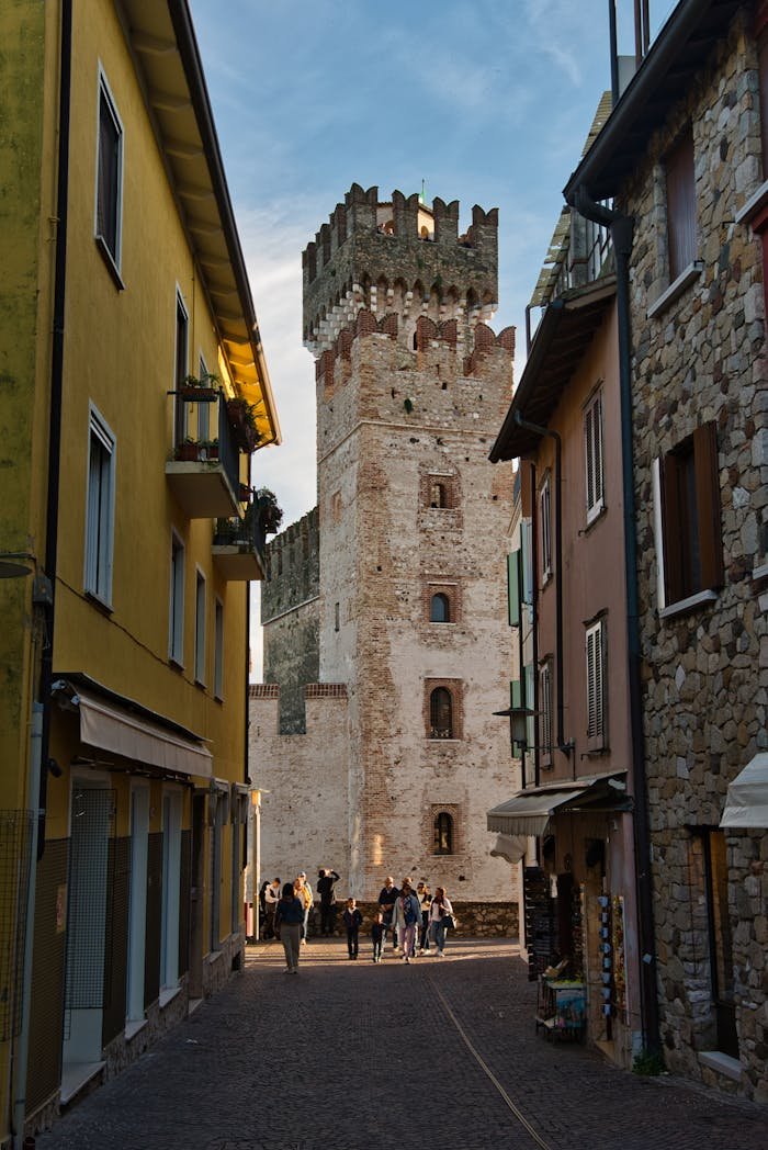 Charming view of a narrow alleyway leading to the historic Sirmione Castle in Italy.