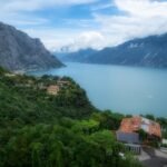 Scenic view of Lake Garda surrounded by the Italian Alps with lush greenery.