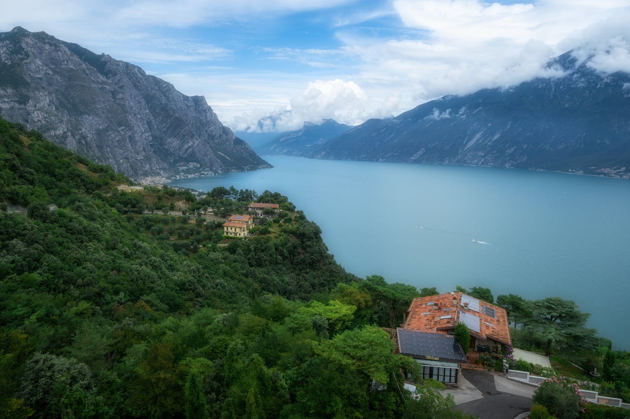 Scenic view of Lake Garda surrounded by the Italian Alps with lush greenery.