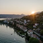 A scenic aerial shot of Salo, Italy on Lake Garda during sunset, showcasing waterfront and mountains.