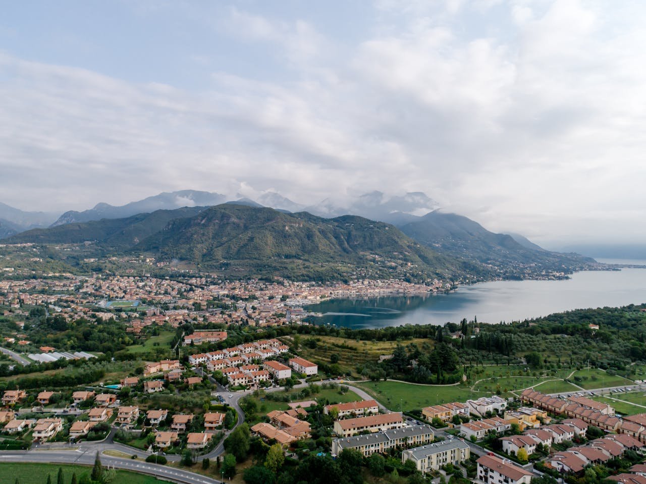 Scenic aerial shot of Salo, Italy with Lake Garda and mountains in summer.