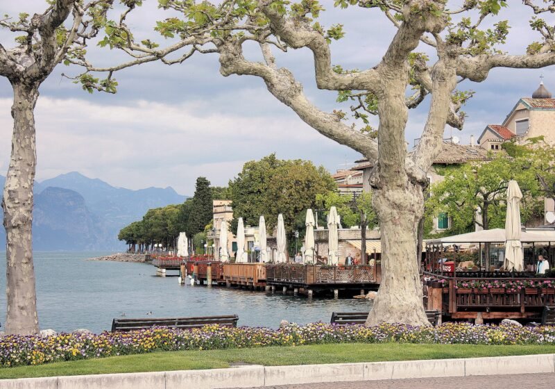Restaurant terraces under plane trees on the lakefront at Torri del Benaco